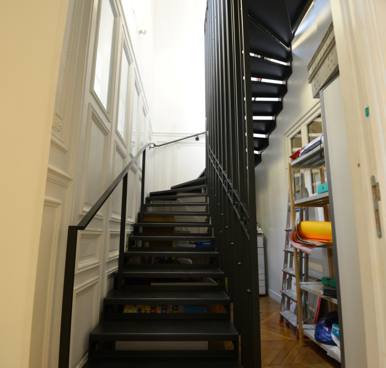escalier droit acier noir vu de face avec herse centrale.