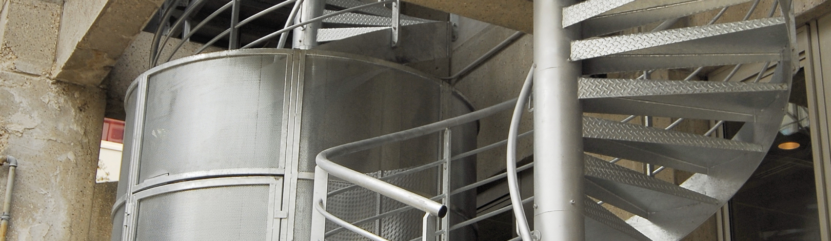 vue sur l'escalier en acier galvanisé et la cage anti intrusion au départ de l'escalier de secours