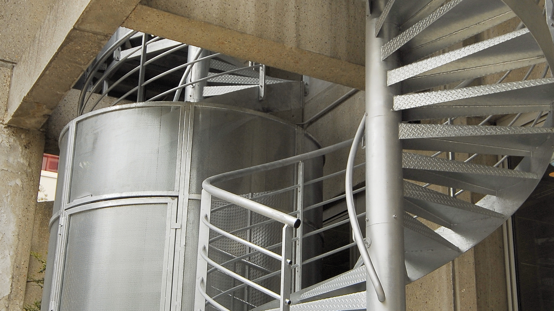 vue sur l'escalier en acier galvanisé et la cage anti intrusion au départ de l'escalier de secours